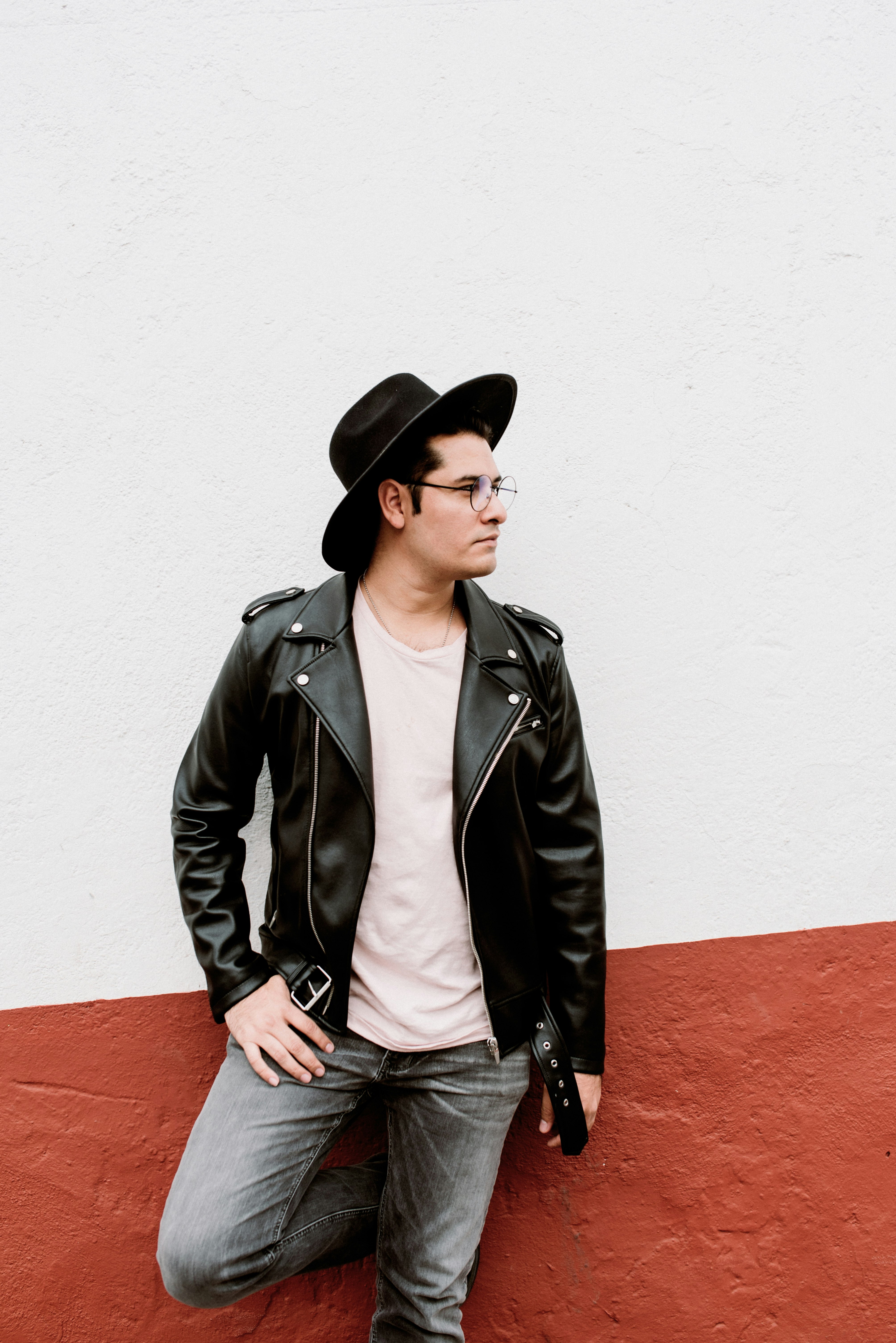 man leaning on white and red wall